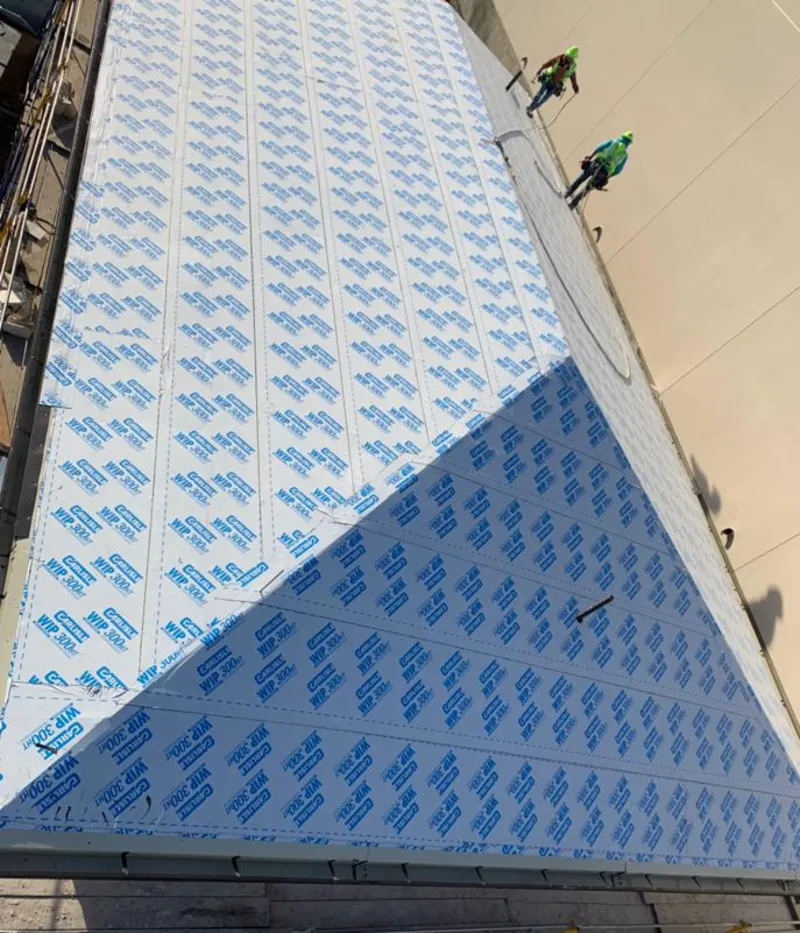 Professional roofers installing underlayment on a metal roof in Key Biscayne